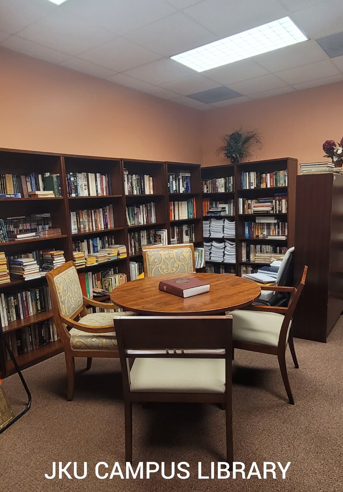 JKU campus library with bookshelves and a study table
